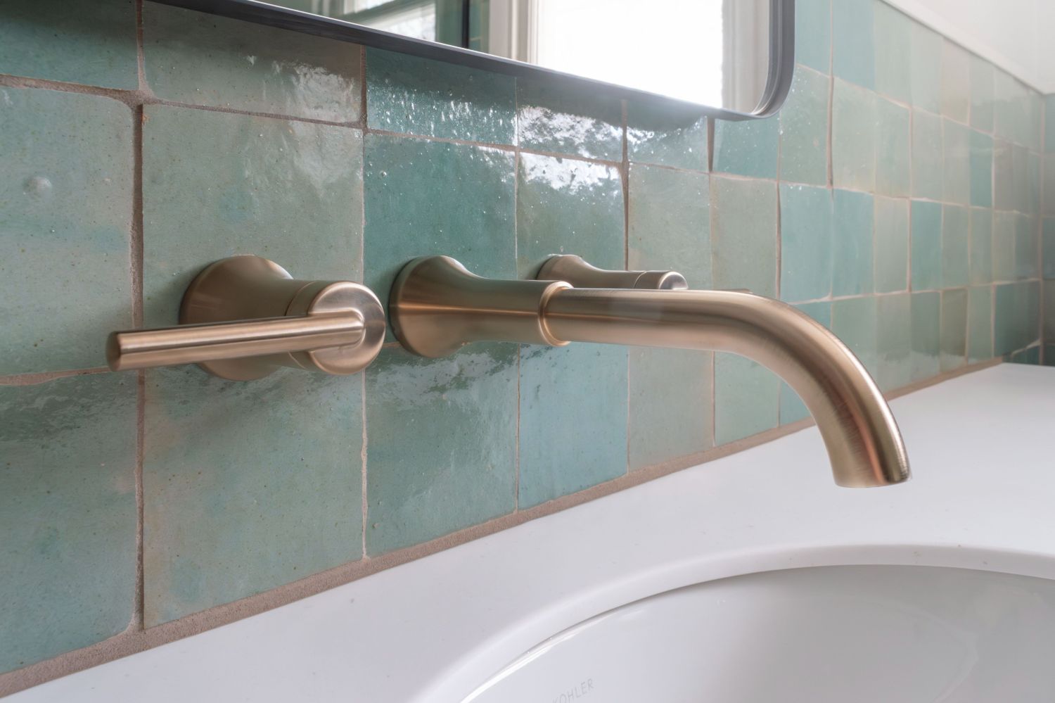 Delta Triassic wall mount faucet with corian top and lili Agave Green Zellige Tile in bathroom