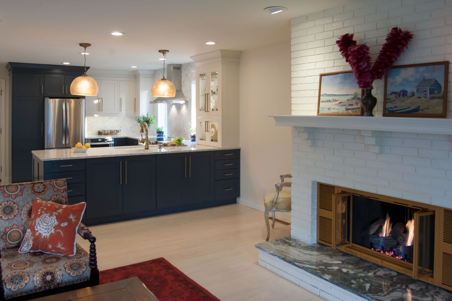 Navy and white kitchen open to living room why painted brick