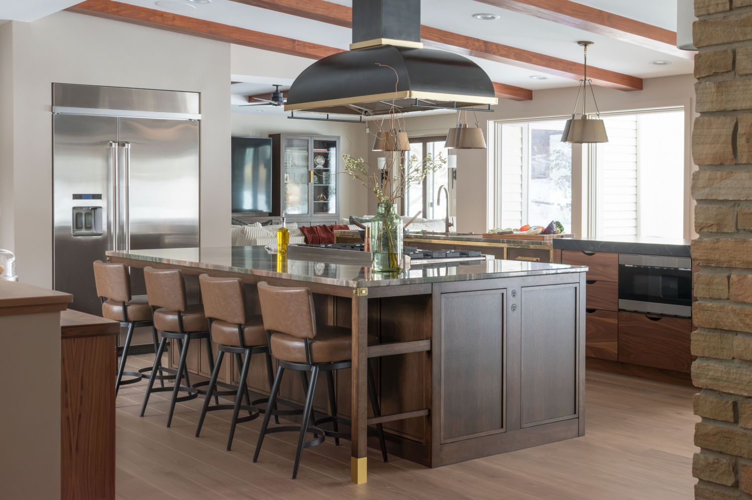 kitchen island with rangecraft hood plato cabinetry and Carlisle wood flooring