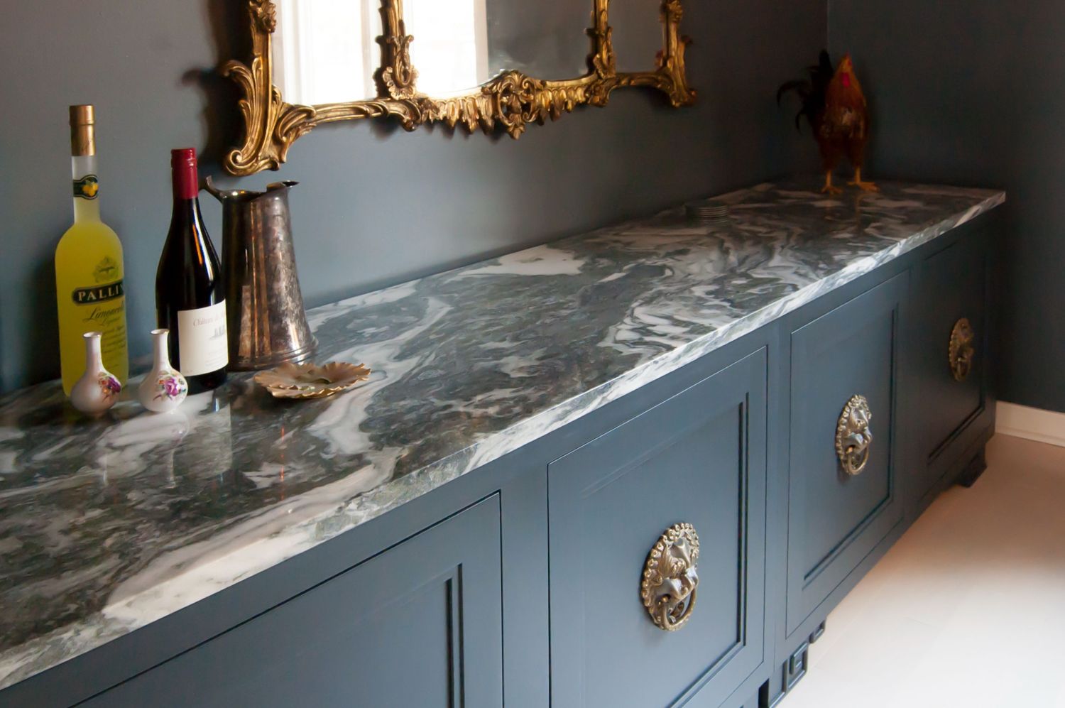 Bianco Giada countertops in dining room buffet with navy cabinetry