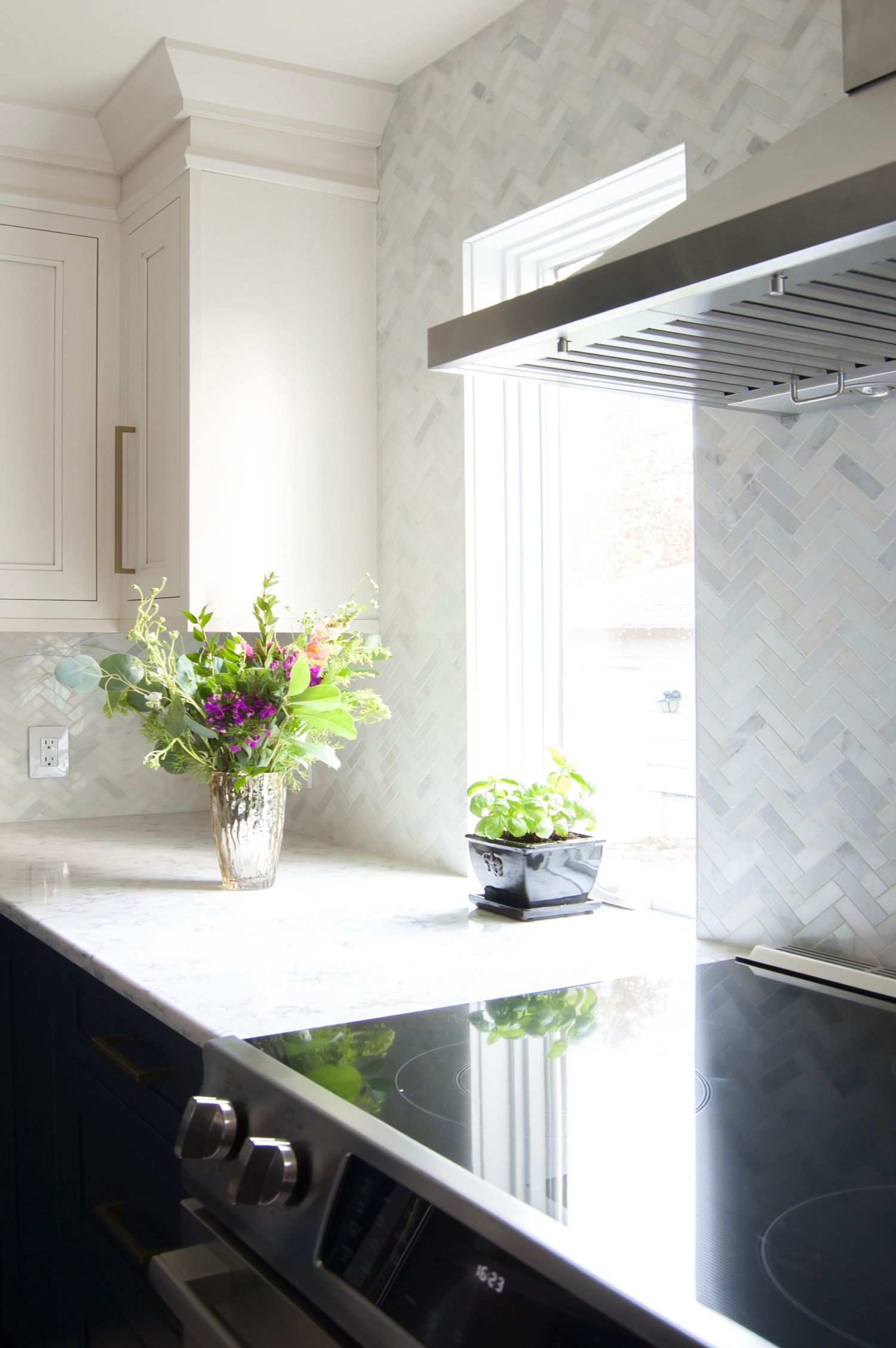 slide in range in kitchen with Rococo Quartz tops and winter sky mosaic backsplash