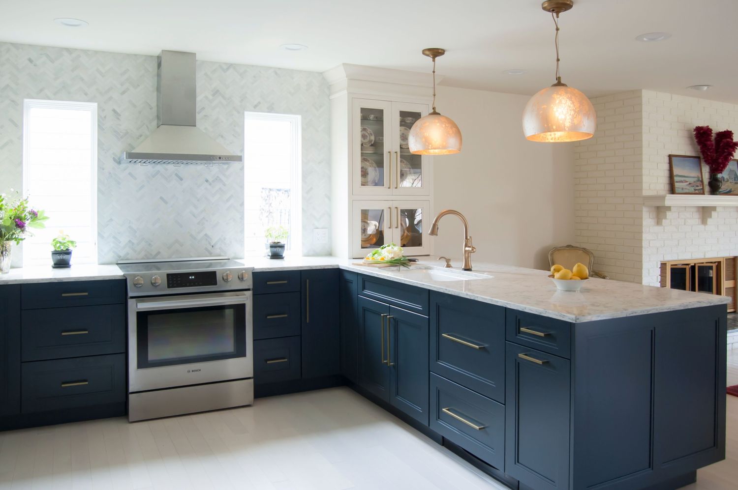 Navy and white cabinetry in kitchen with peninsula and slide in range