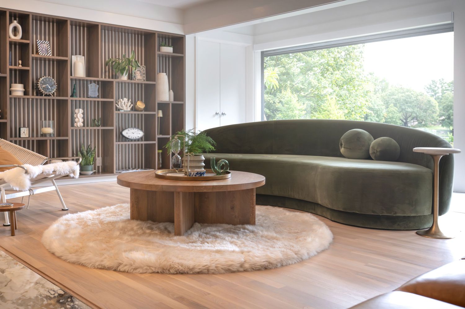 Livingroom with lake view, curved sofa, custom white oak bookcase