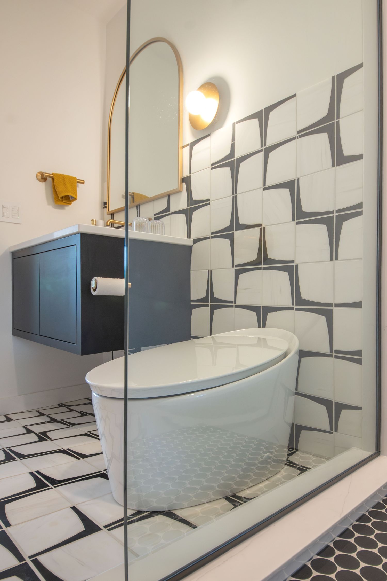 marble floor and wall tile in guest bathroom with floating vanity