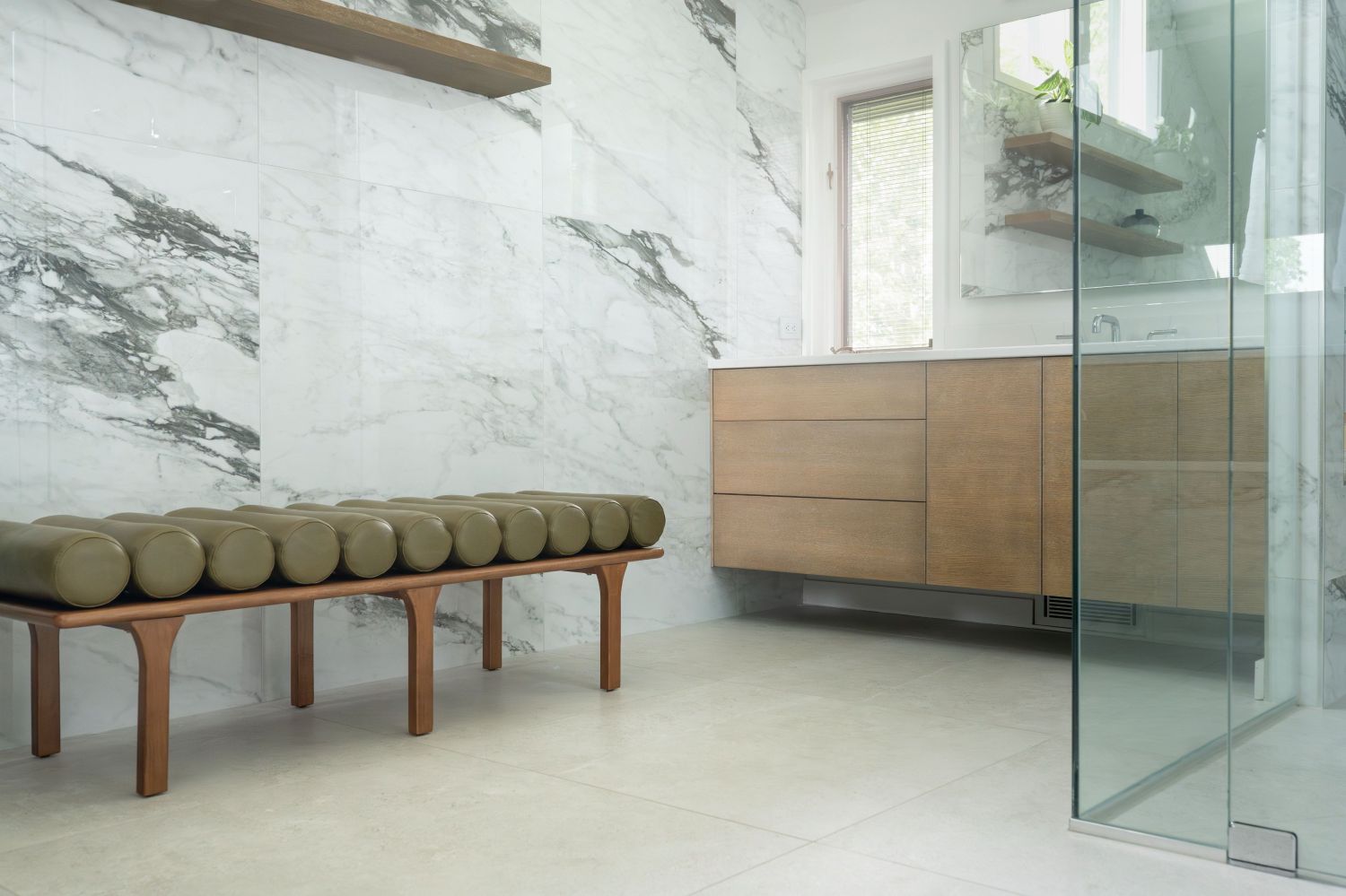primary bath with bench imola tile maple floating vanity and natural light