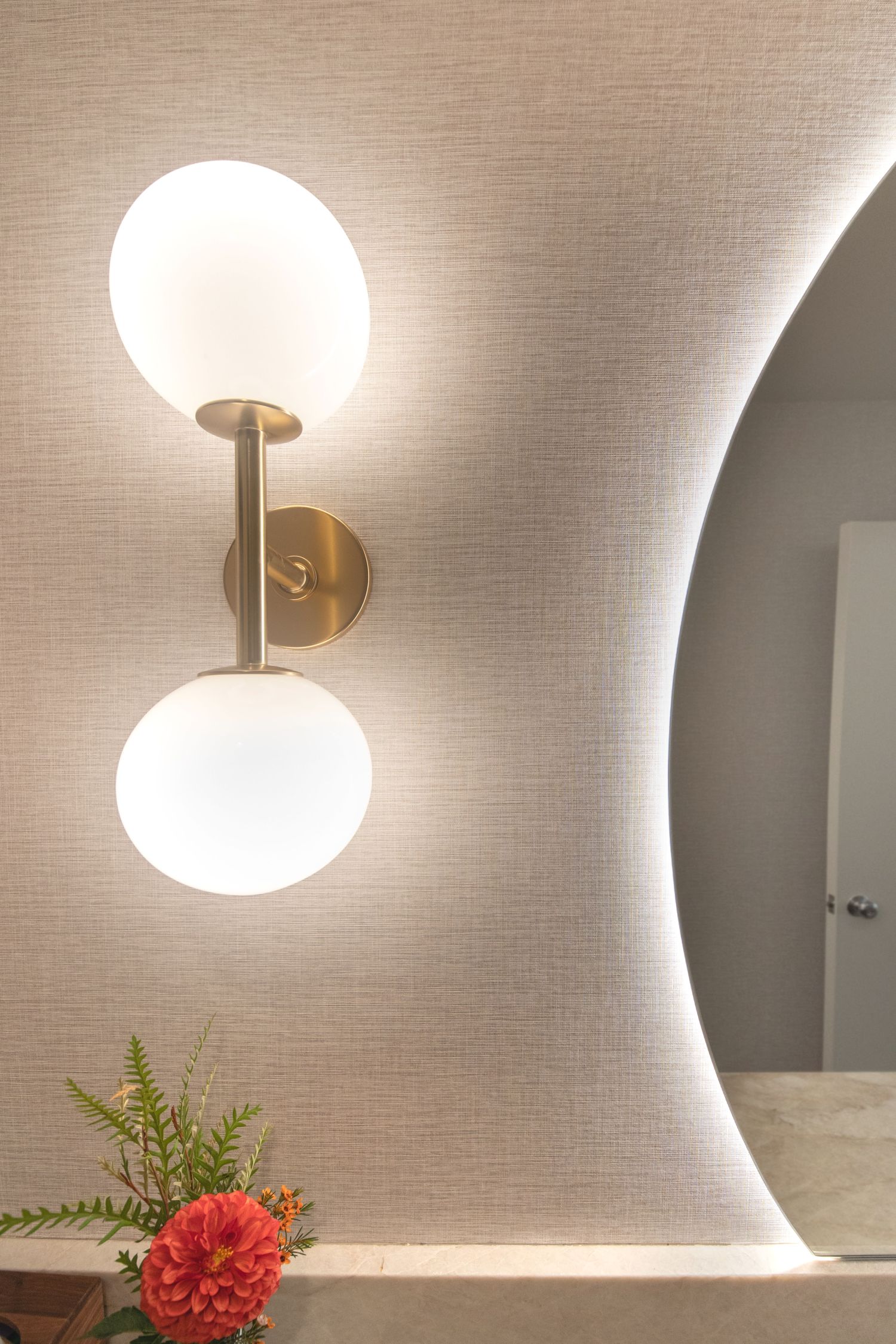 wall sconce and backlit mirror in powder room