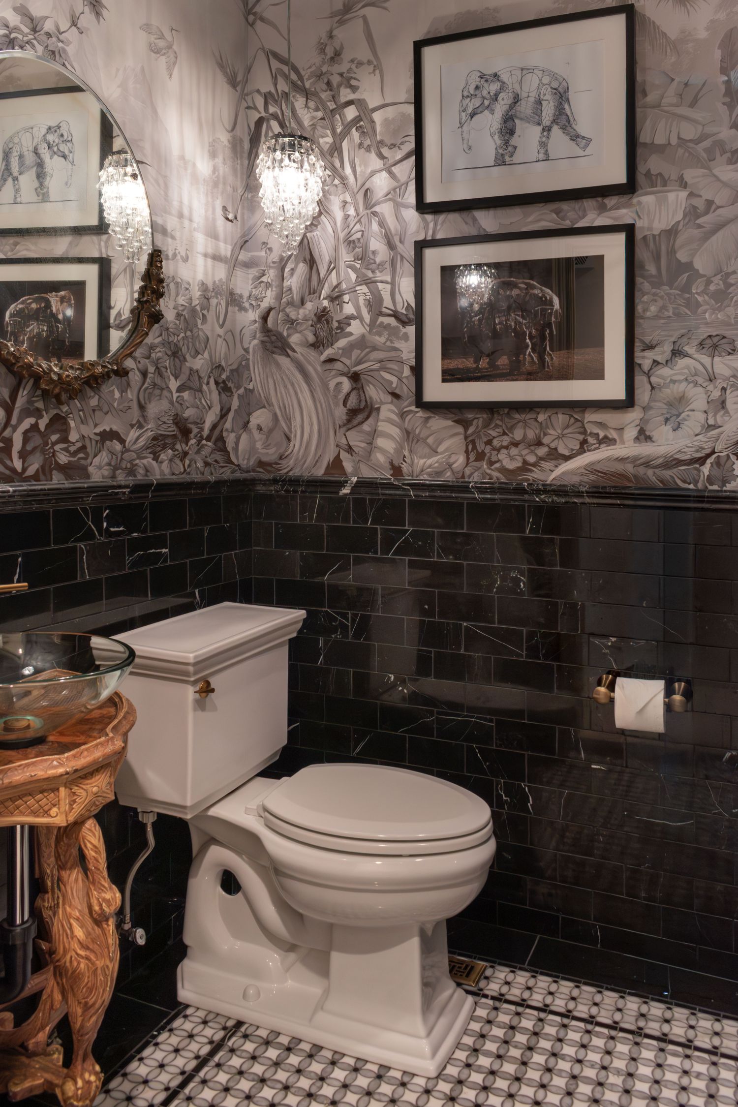 Black marble tile in bathroom with black and white parquet floor tile. Kohler Memiors toilet in guest bath Antique vanity