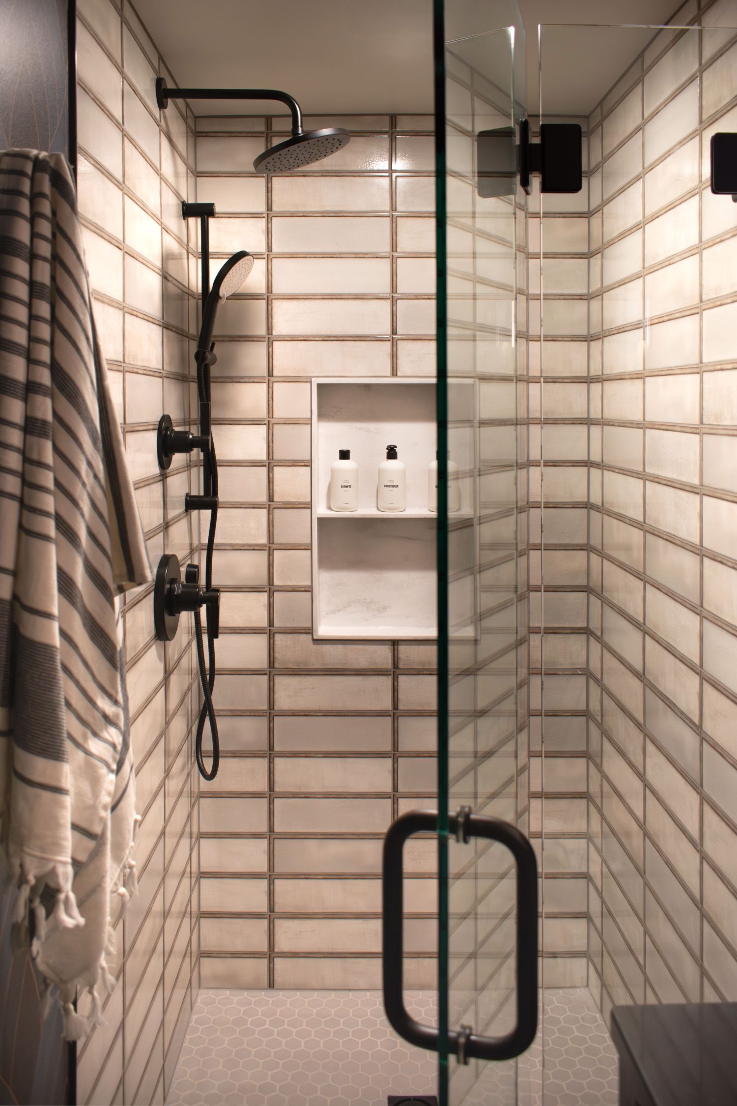 Walk in shower with Diesel white wall tile profiled shower faucet and corian  niches