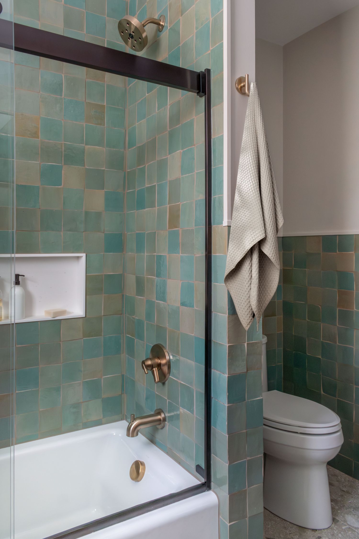 Tub shower enclosure with Lili Agave Green Zellige Tile Delta trinsic faucets corian niche Kohler bellwether tub