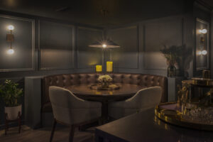 Basement lounge with dark blue walls, custom banquette seating, and a corner poker table