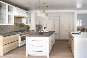 Luxury custom kitchen cabinets with sequence-matched wood grain and integrated SubZero refrigerator drawer showcasing high-end cabinetry craftsmanship